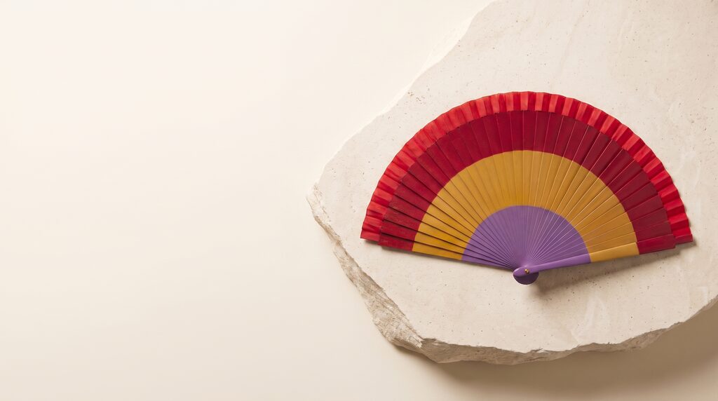 Abanico Bandera Republicana Recta abierto sobre una losa de piedra clara: tres franjas rectas y concéntricas en rojo, amarillo y morado